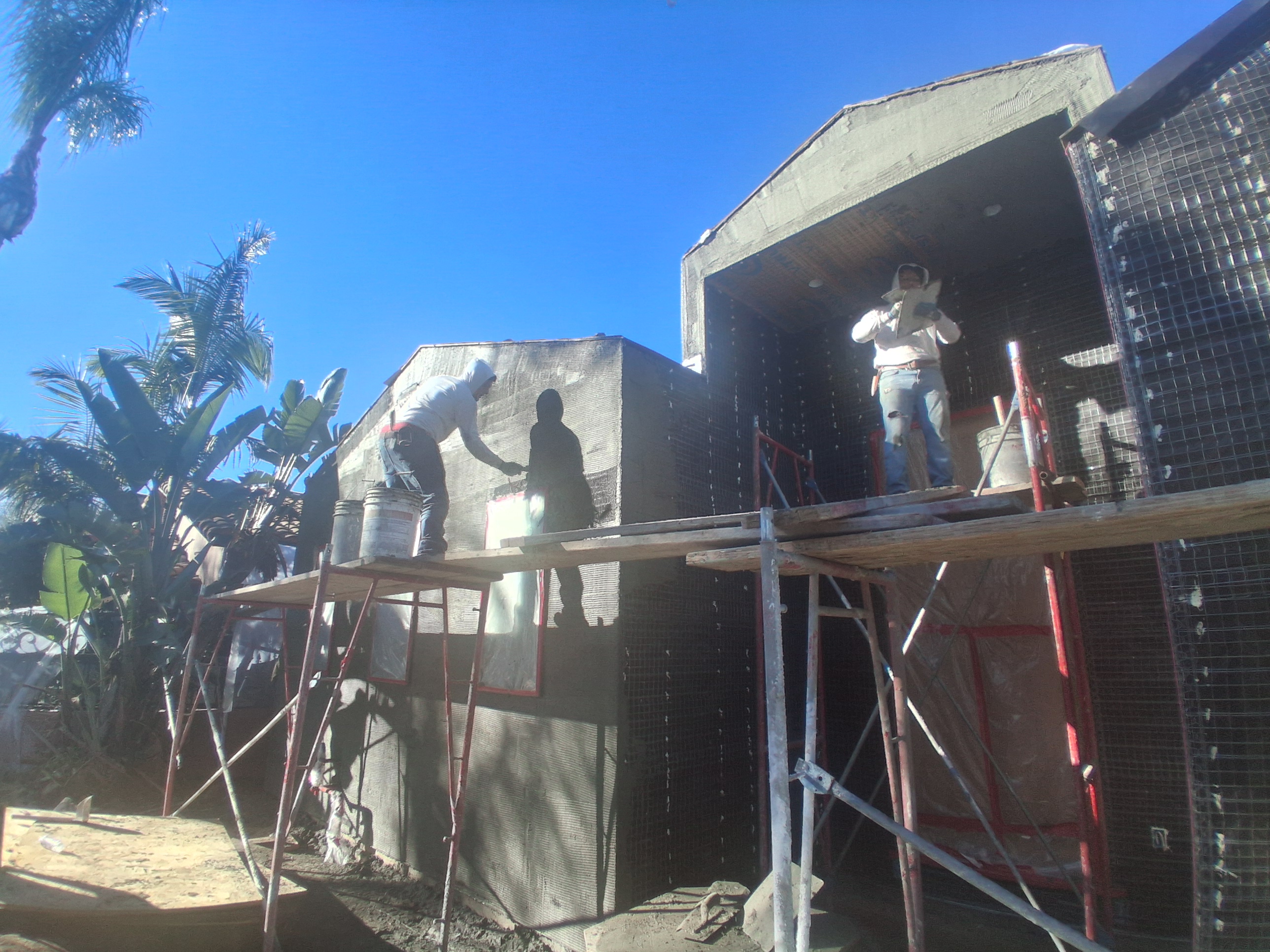 Residential exterior stucco work in progress with scaffolding
