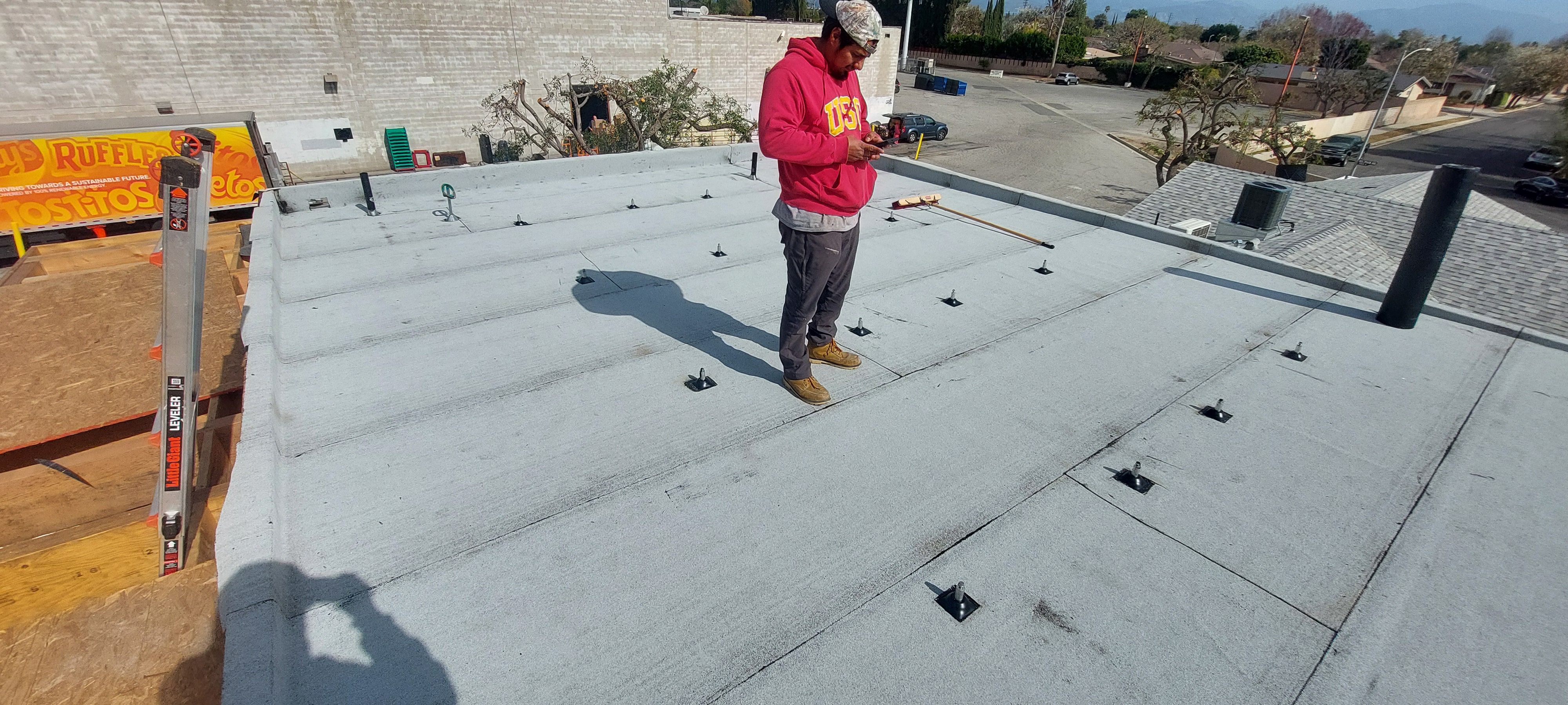Worker reviewing a newly placed concrete slab with plumbing penetrations